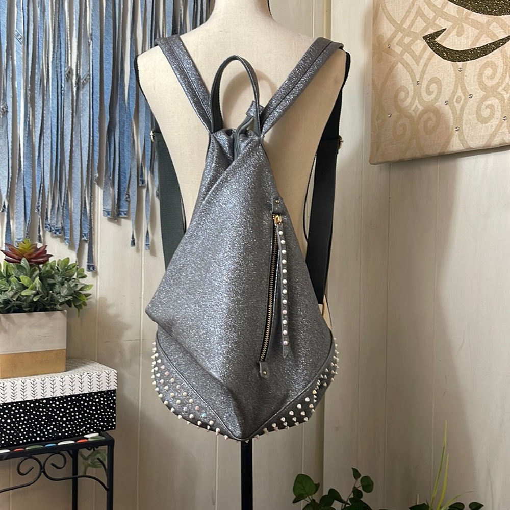 Metallic silver and multi color stud fold over backpack. Vegan leather.